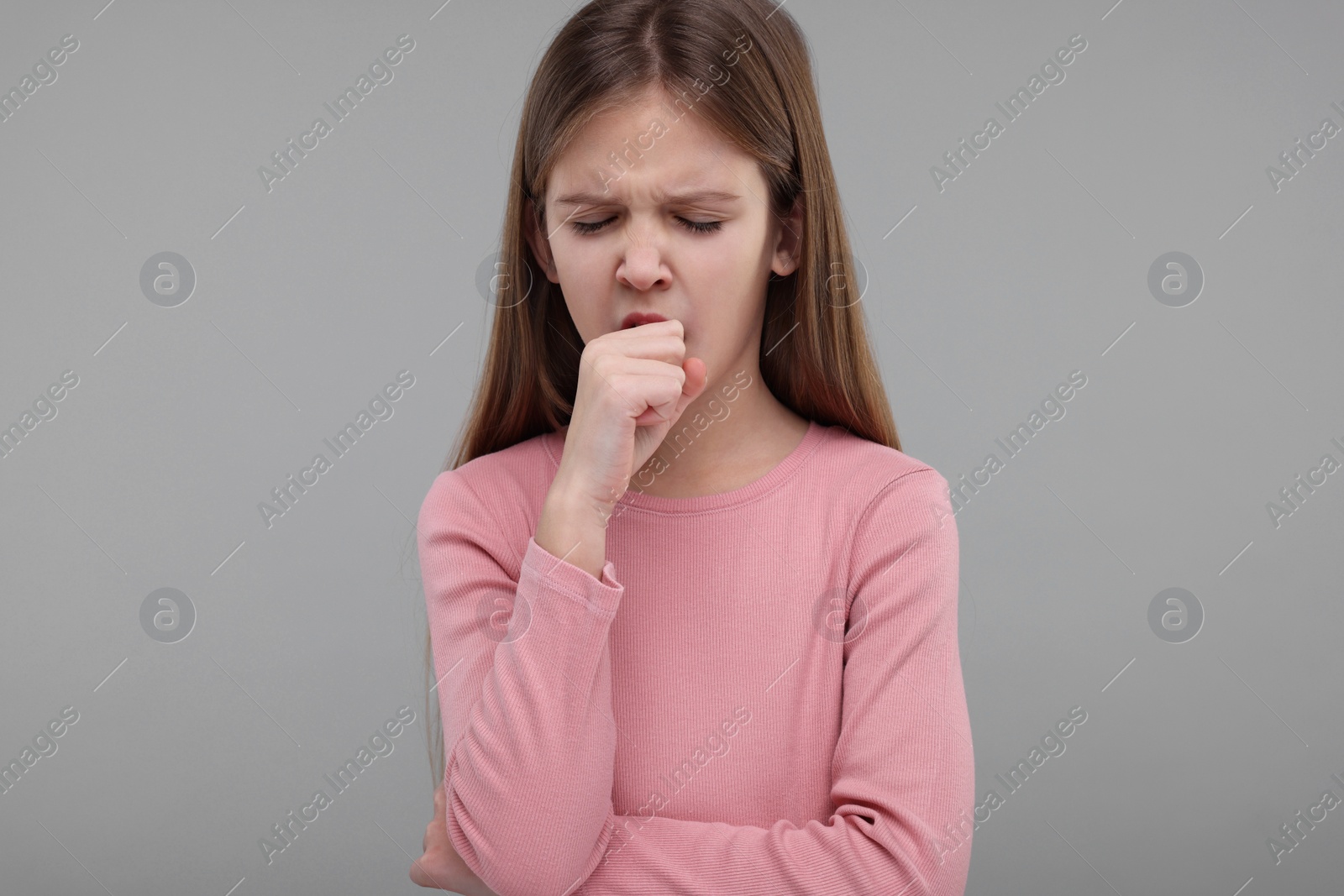 Photo of Sick girl coughing on gray background. Cold symptoms