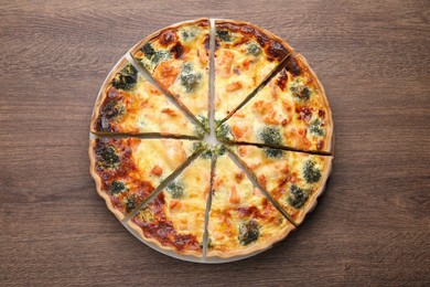 Delicious homemade quiche with salmon and broccoli on wooden table, top view