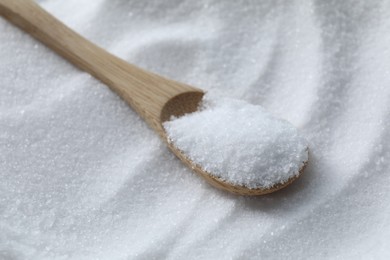 Wooden spoon on white sea salt, closeup