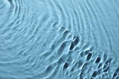 Photo of Rippled surface of clear water on light blue background, top view