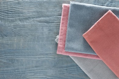 Photo of Different colorful napkins on wooden table, top view. Space for text