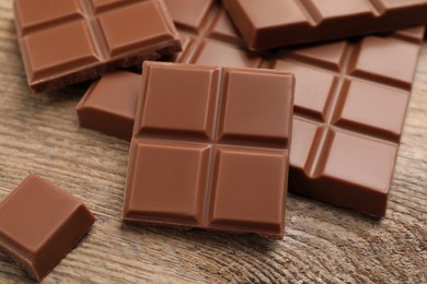 Photo of Delicious milk chocolate on wooden table, closeup