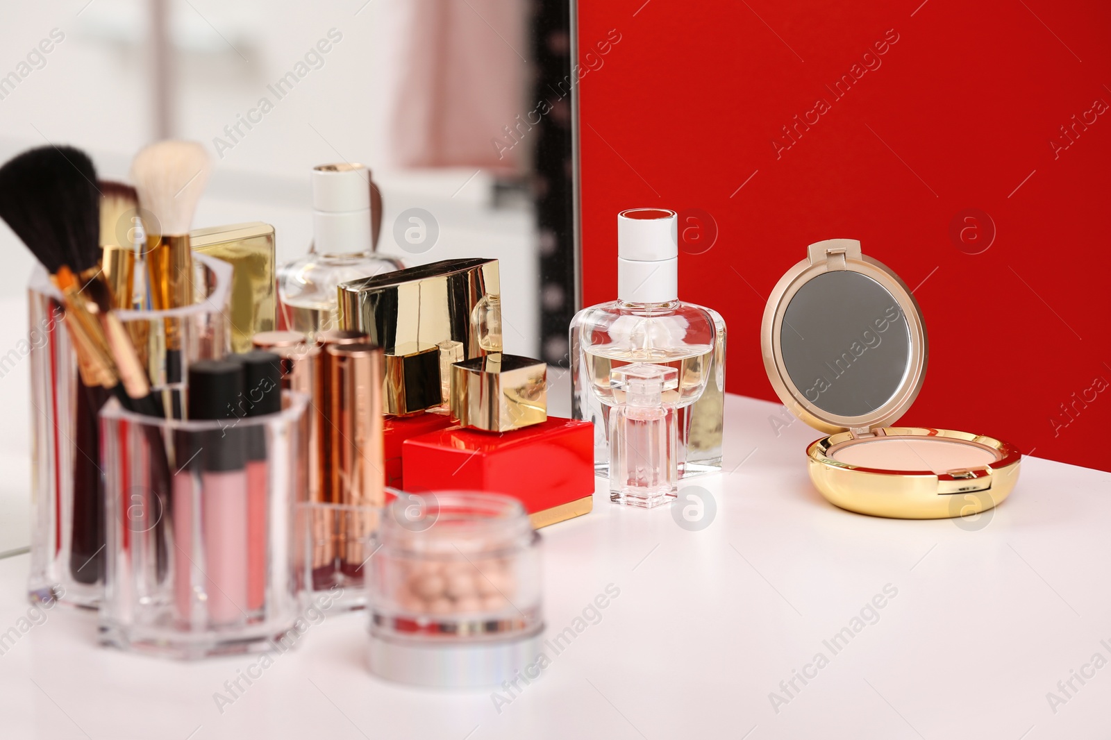 Photo of Luxury cosmetics and beauty accessories on dressing table. Interior element