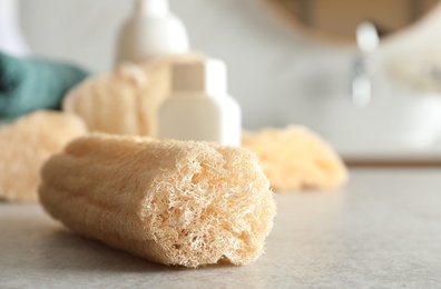 Photo of Natural loofah sponge on table in bathroom, closeup. Space for text