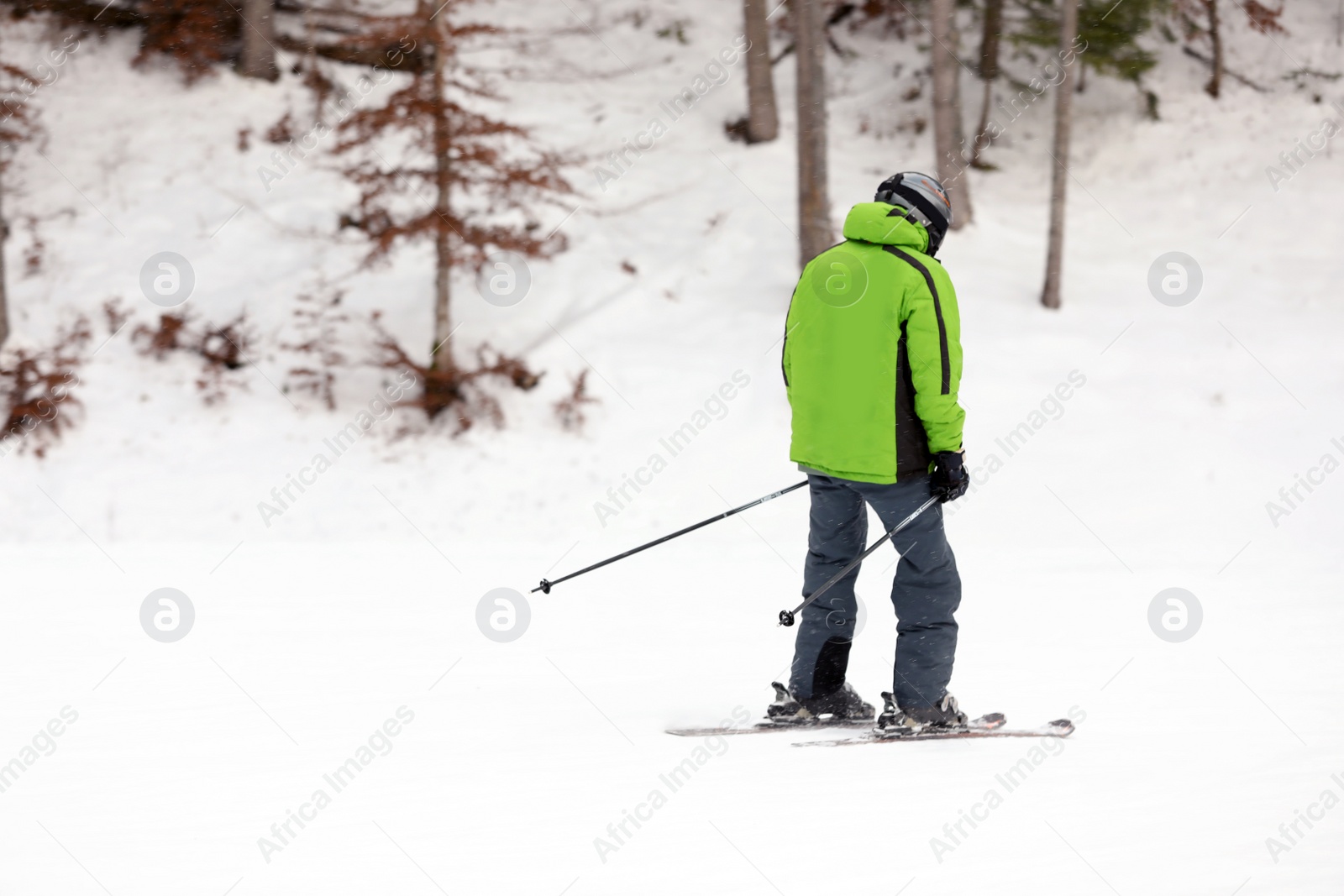 Photo of Skier on slope at resort, space for text. Winter vacation