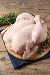 Fresh raw chicken with spices on wooden table