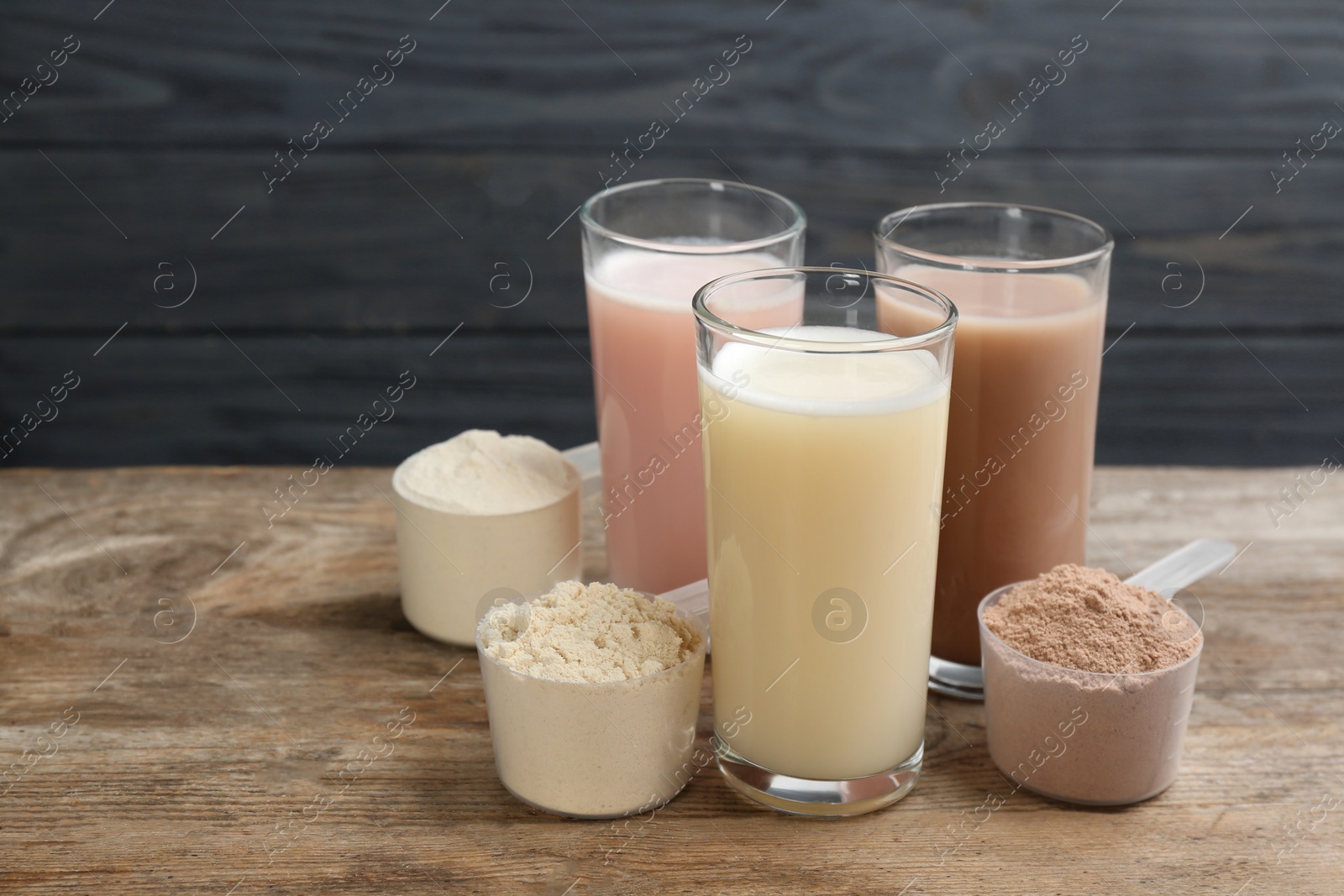 Photo of Protein shakes and powder on wooden table