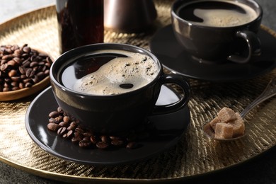 Photo of Cups of coffee, sugar and beans on grey table