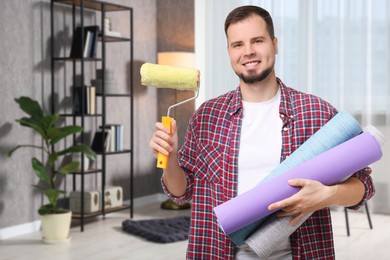 Man with wallpaper roll and roller in room