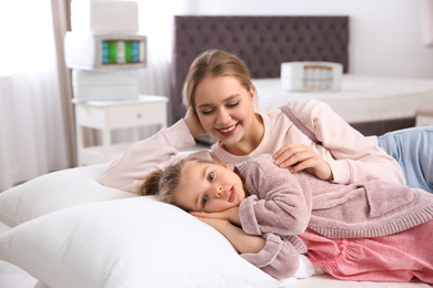 Mother and daughter testing mattress in store