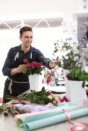 Photo of Male florist creating beautiful bouquet in flower shop
