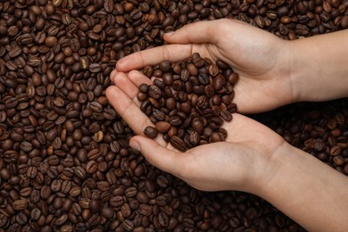 Photo of Woman with roasted coffee beans, top view