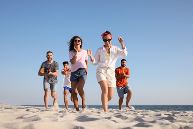 Group of friends with water guns having fun on beach