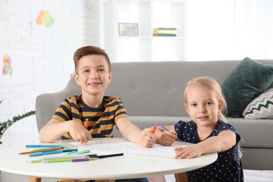 Photo of Cute little children drawing together at home
