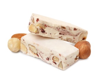 Photo of Pieces of delicious nougat and nuts on white background