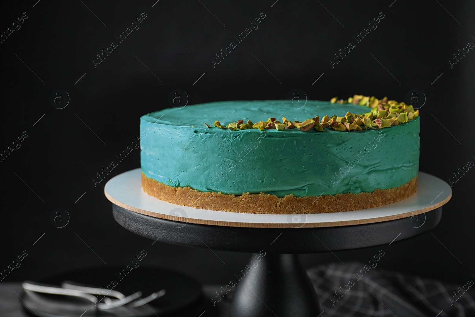 Photo of Delicious homemade spirulina cheesecake against black background