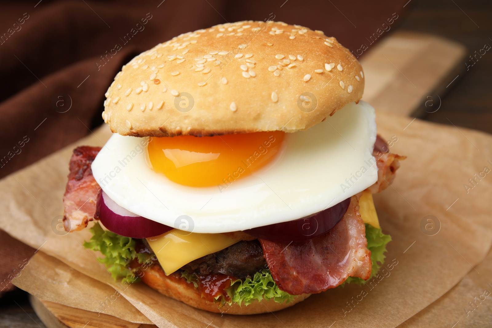 Photo of Delicious burger with fried egg on table, closeup