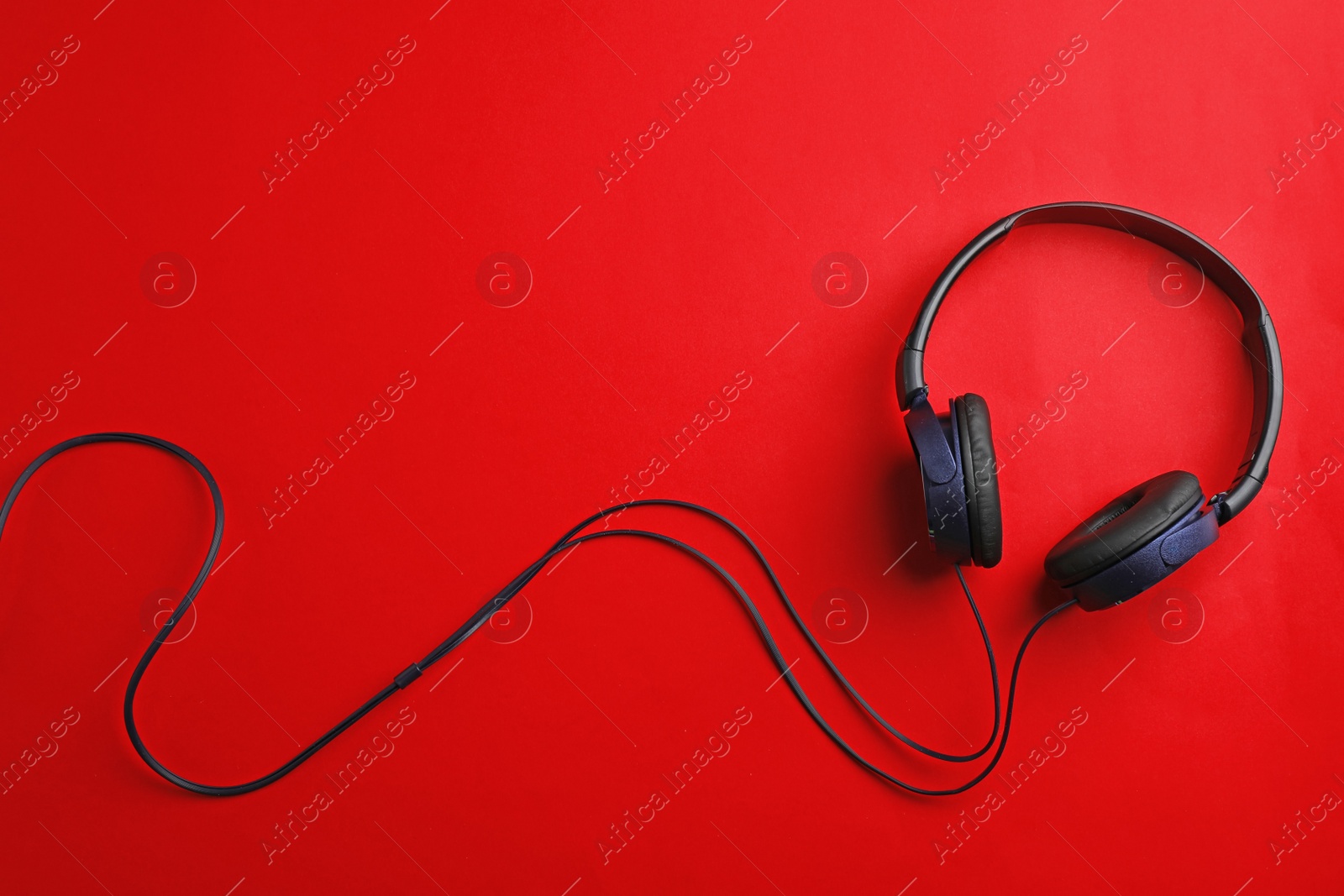 Photo of Stylish headphones on color background, top view. Space for text