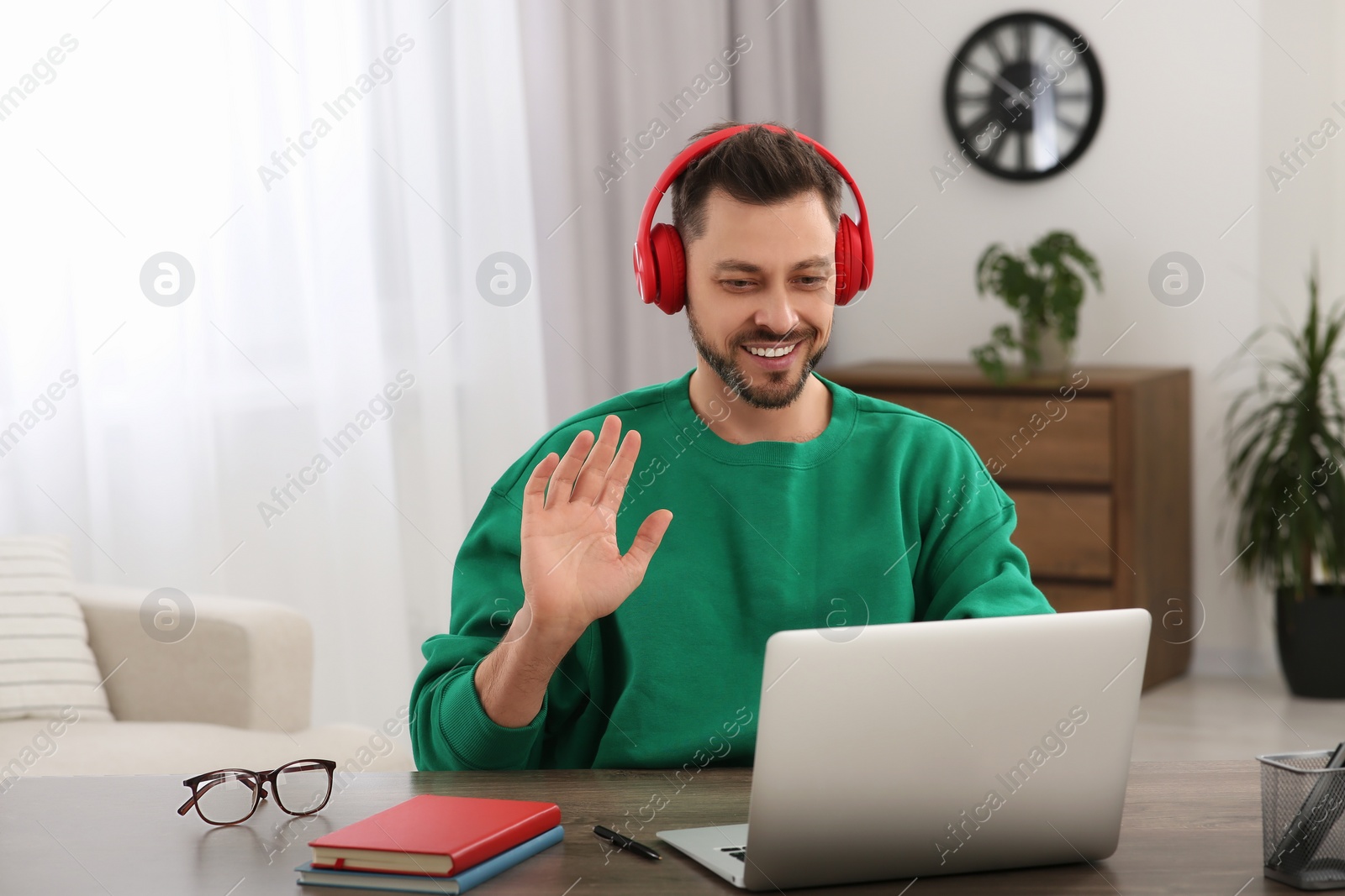 Photo of Man in headphones studying on laptop at home. Online translation course