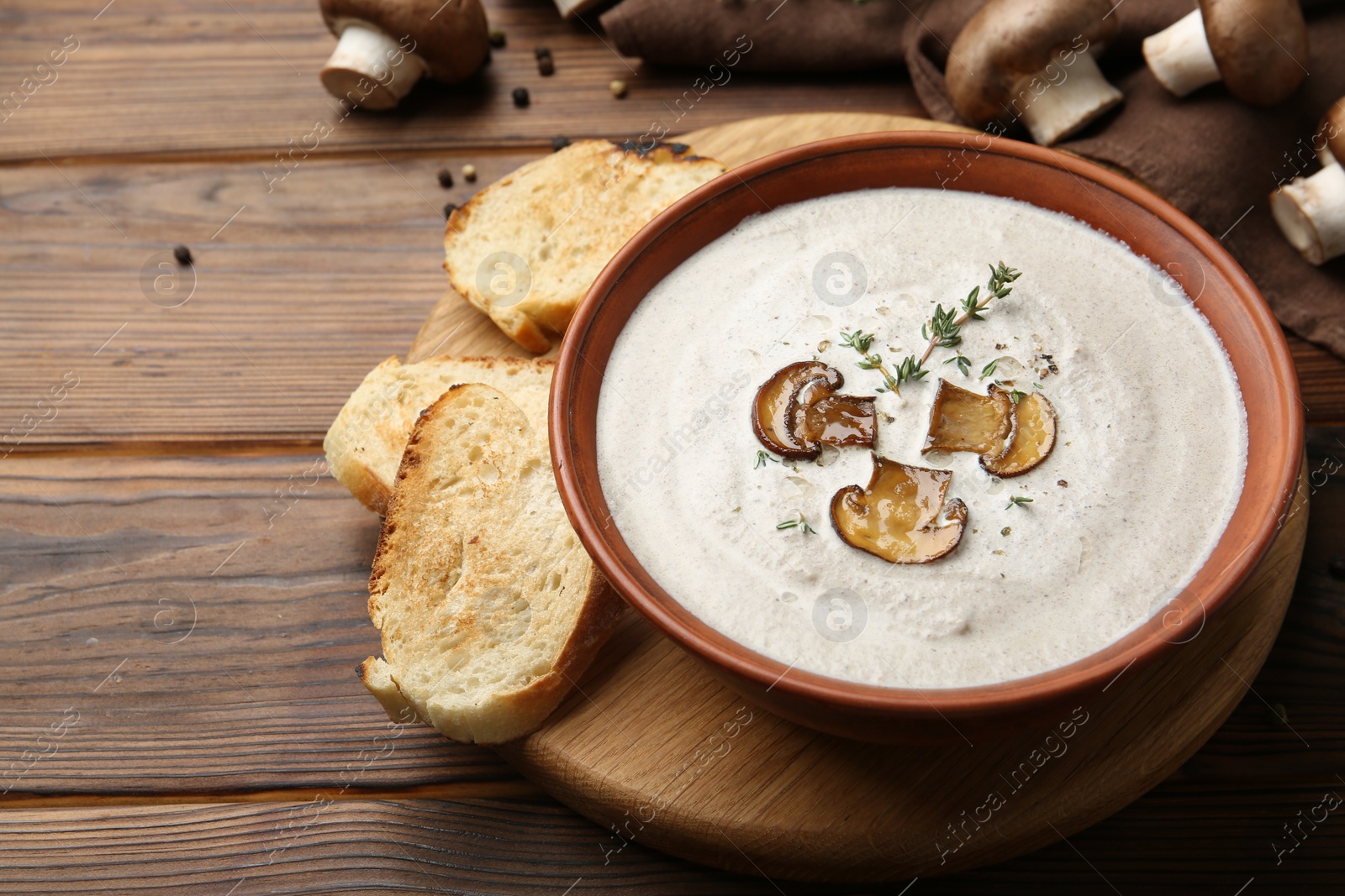 Photo of Fresh homemade mushroom soup in ceramic bowl on wooden table. Space for text