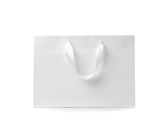 Photo of Paper shopping bag with ribbon handles on white background. Mockup for design