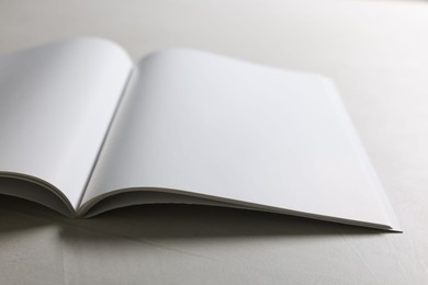 Photo of Open notebook with blank pages on grey textured table, closeup. Mockup for design