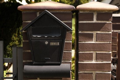 Photo of Black metal letter box on brick wall outdoors