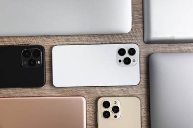 Many different modern gadgets on wooden table, flat lay