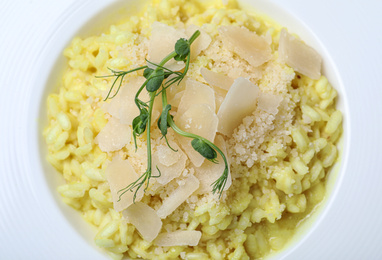 Photo of Delicious risotto with cheese in plate, closeup