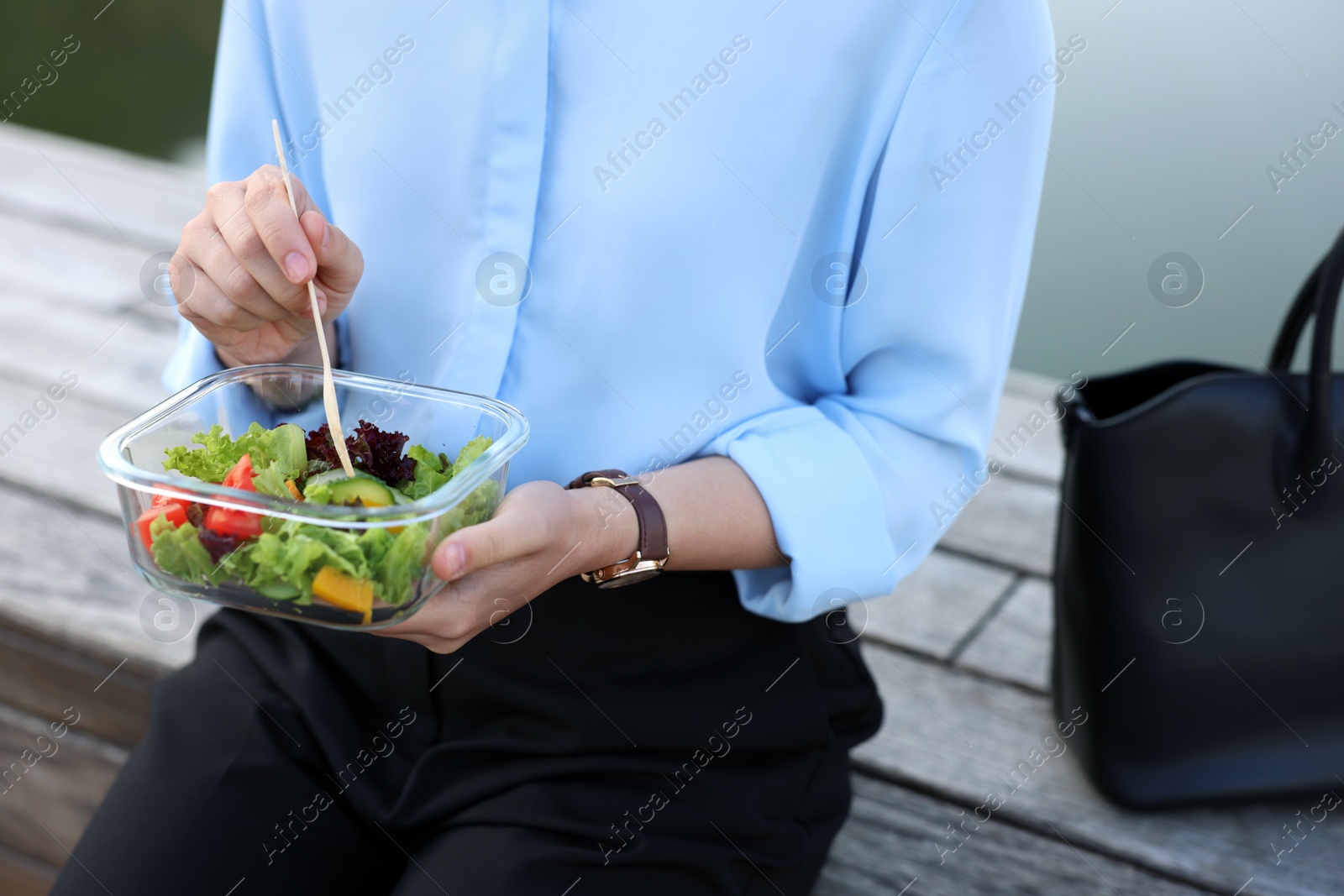 Photo of Businesswoman eating lunch during break outdoors, closeup