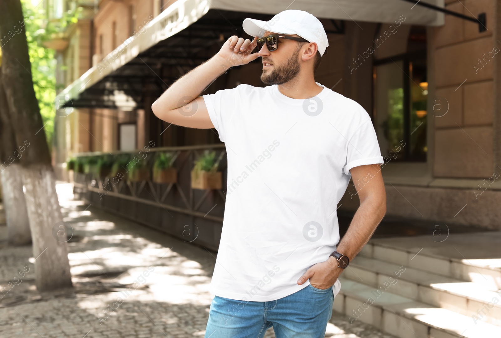 Photo of Young man wearing white t-shirt on street