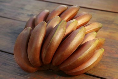 Tasty purple bananas on wooden table, closeup