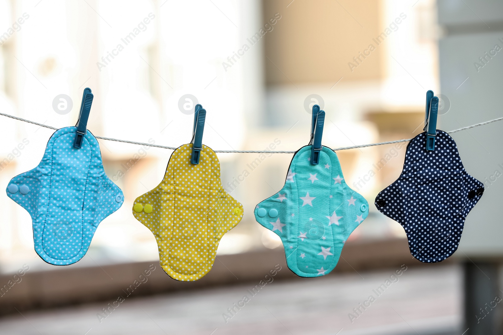 Photo of Many different menstrual cloth pads hanging on rope outdoors