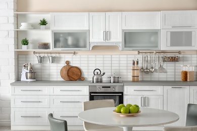 Stylish kitchen interior with dining table and chairs