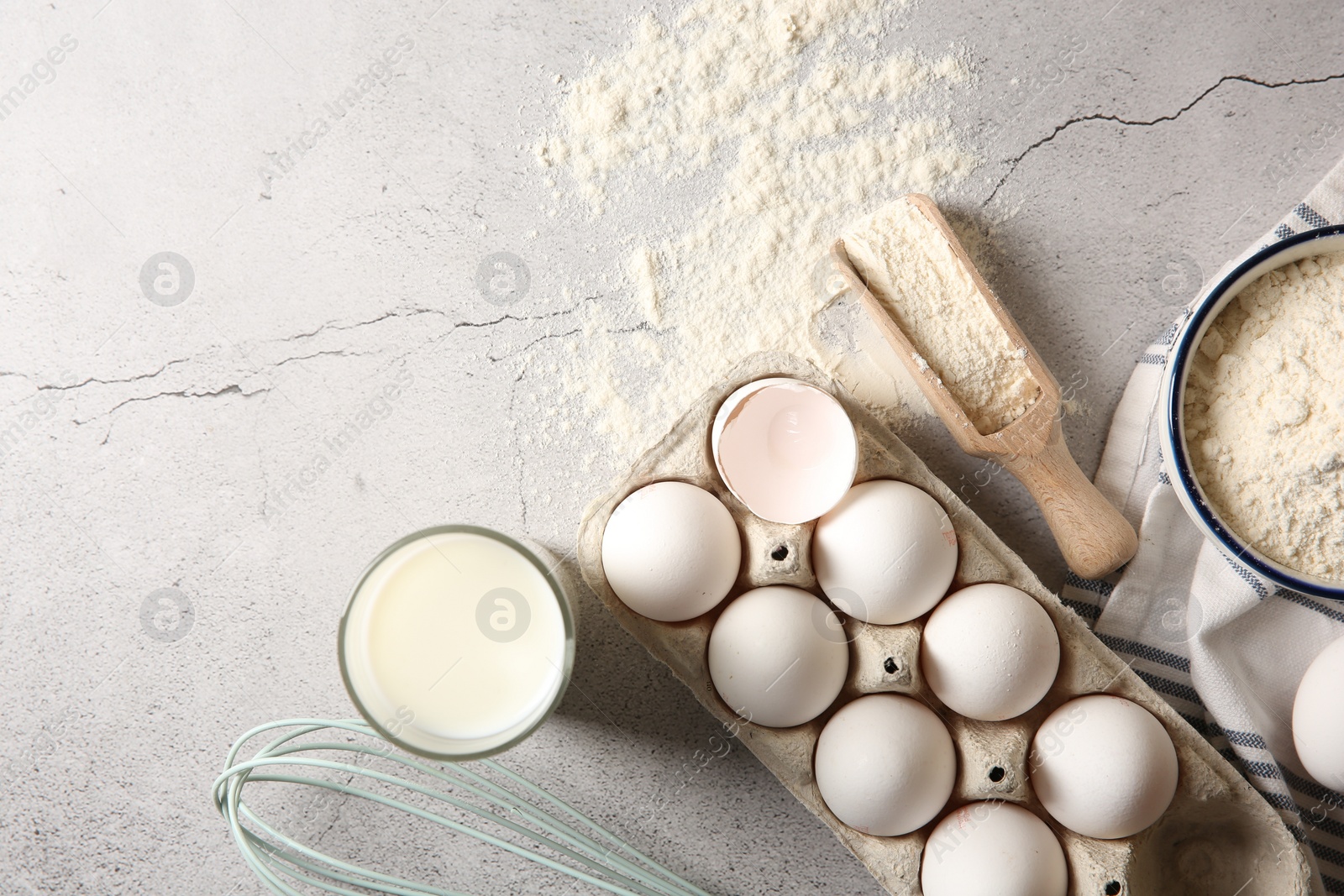 Photo of Making dough. Flour, eggs, milk and tools on light textured table, flat lay. Space for text