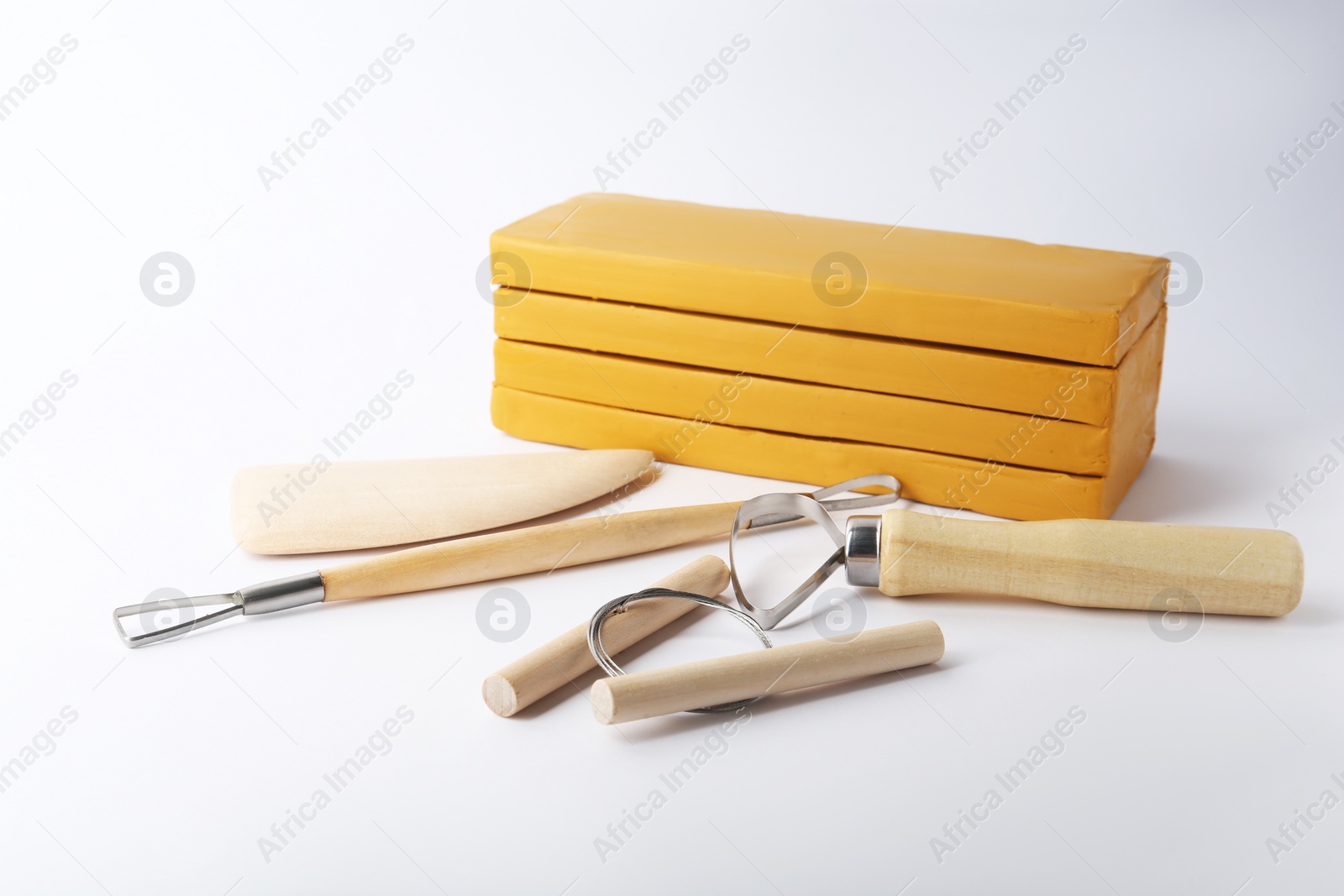 Photo of Clay and different modeling tools on white background