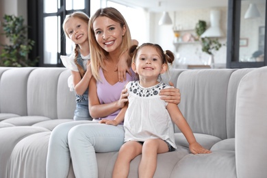 Photo of Cute little girls with their mother in living room