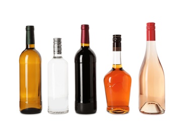 Bottles with different alcoholic drinks on white background