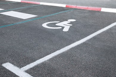 Photo of Car parking lot with wheelchair symbol outdoors