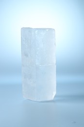 Photo of Blocks of clear ice on light blue background