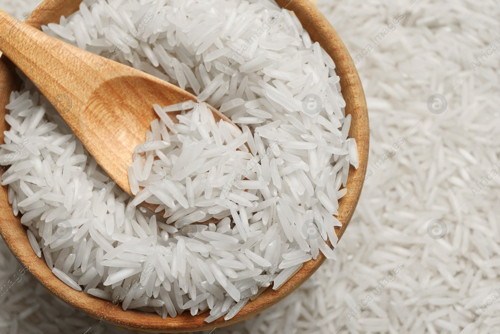 Photo of Raw basmati rice, bowl and spoon, top view