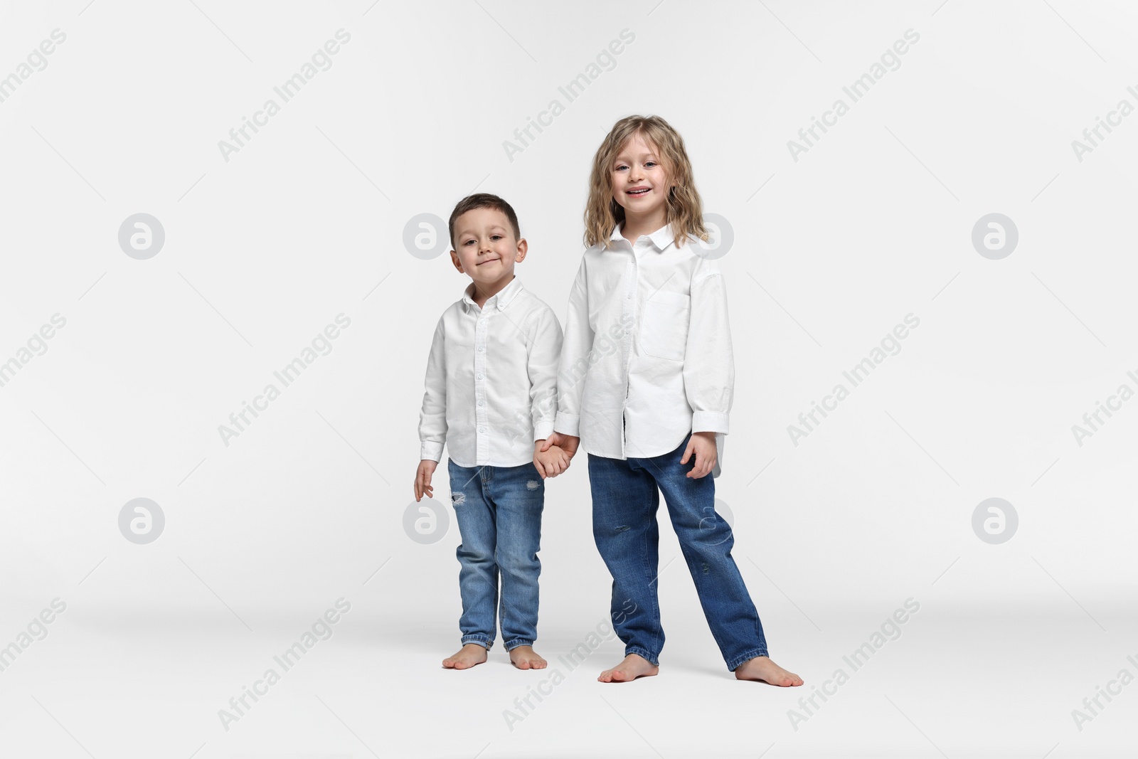 Photo of Cute little children on white background. Happy family