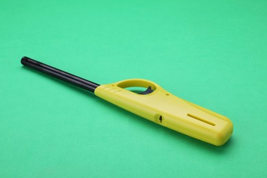 Photo of One bright gas lighter on green background