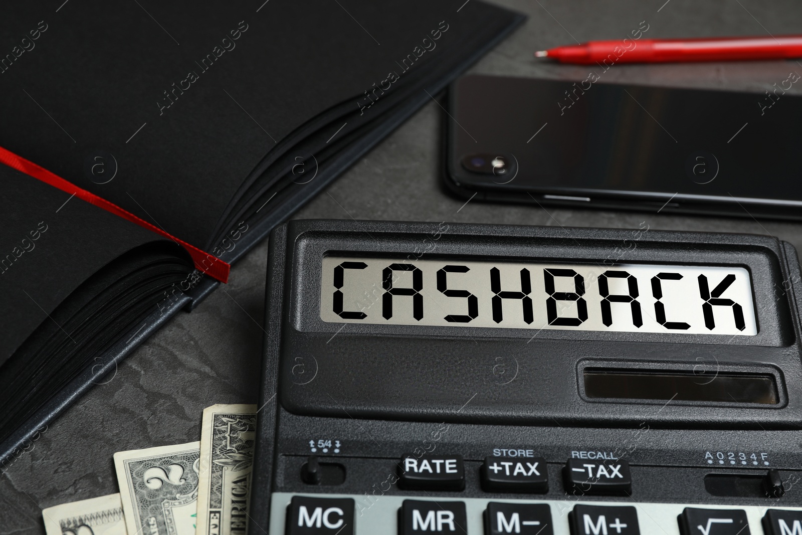 Image of Calculator with word Cashback, money, phone and notebook on dark table, closeup