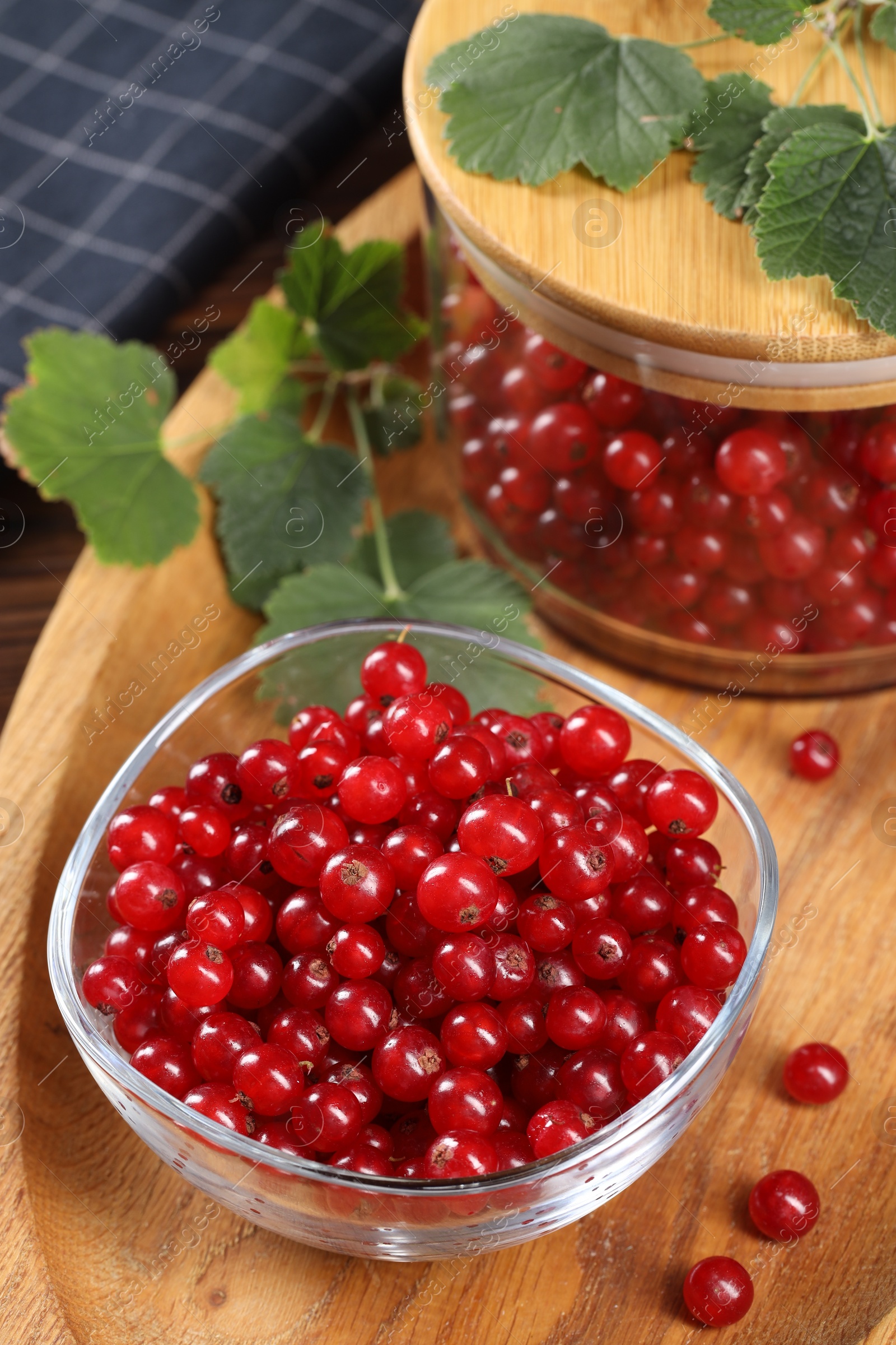 Photo of Ripe red currants and leaves on table, closeup