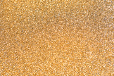 Photo of Beautiful golden shiny glitter as background, top view