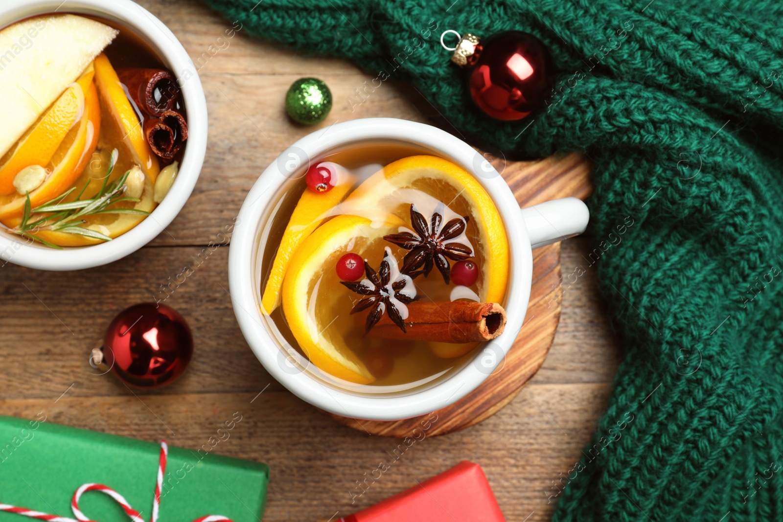 Photo of Aromatic mulled wine on wooden table, flat lay