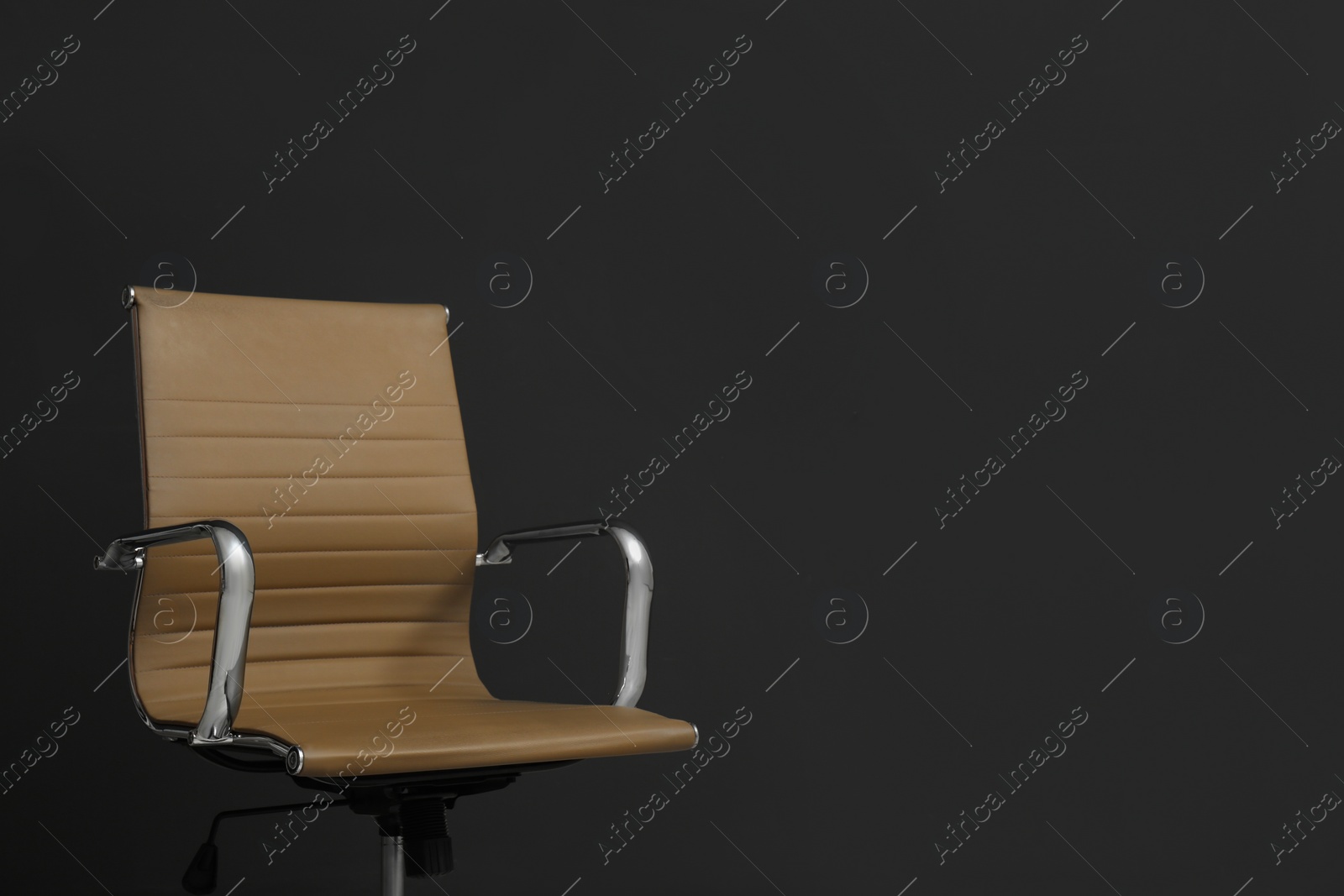 Photo of Comfortable office chair on black background. Space for text