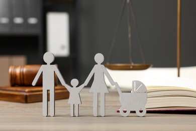 Photo of Family law. Figure of parents with children, book and gavel on wooden table