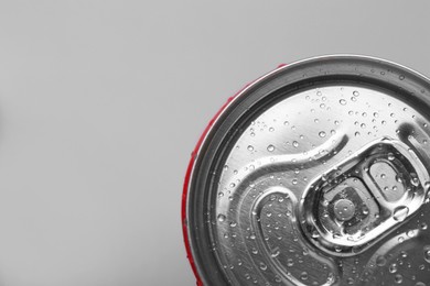 Energy drink in wet can on light grey background, top view. Space for text